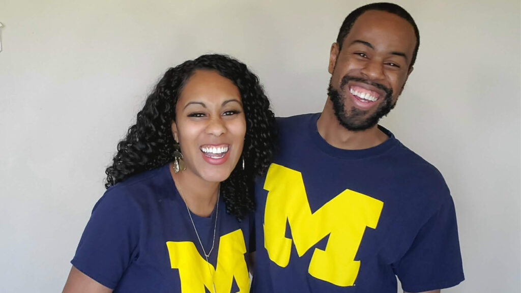 Husband and wife laughing together wearing Michigan shirts for how to have a happy marriage