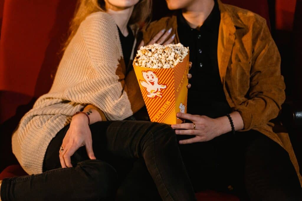 Couple enjoying a movie date night and eating popcorn