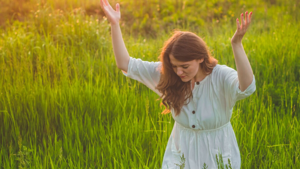 How to Grow Spiritually woman with arms raised in prayer and surrender