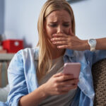 How to Get Through Hard Times upset woman on the couch holding cellphone
